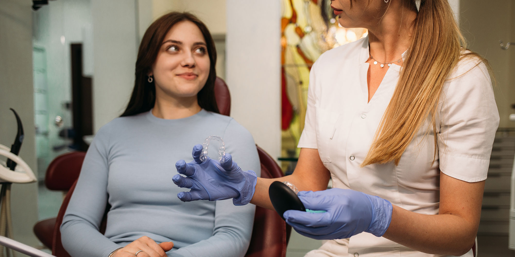 staff member going over dental procedure information with patient on aligners