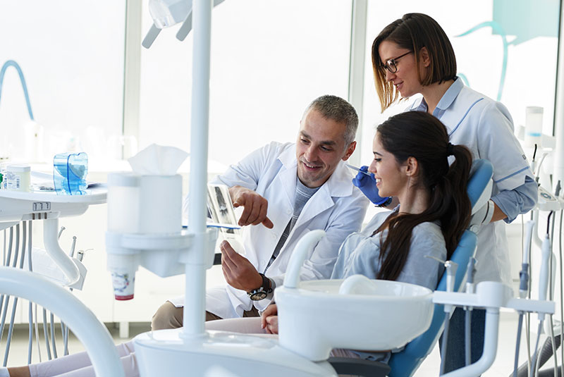 Patient and doctor looking at x-ray of dental procedure for patient