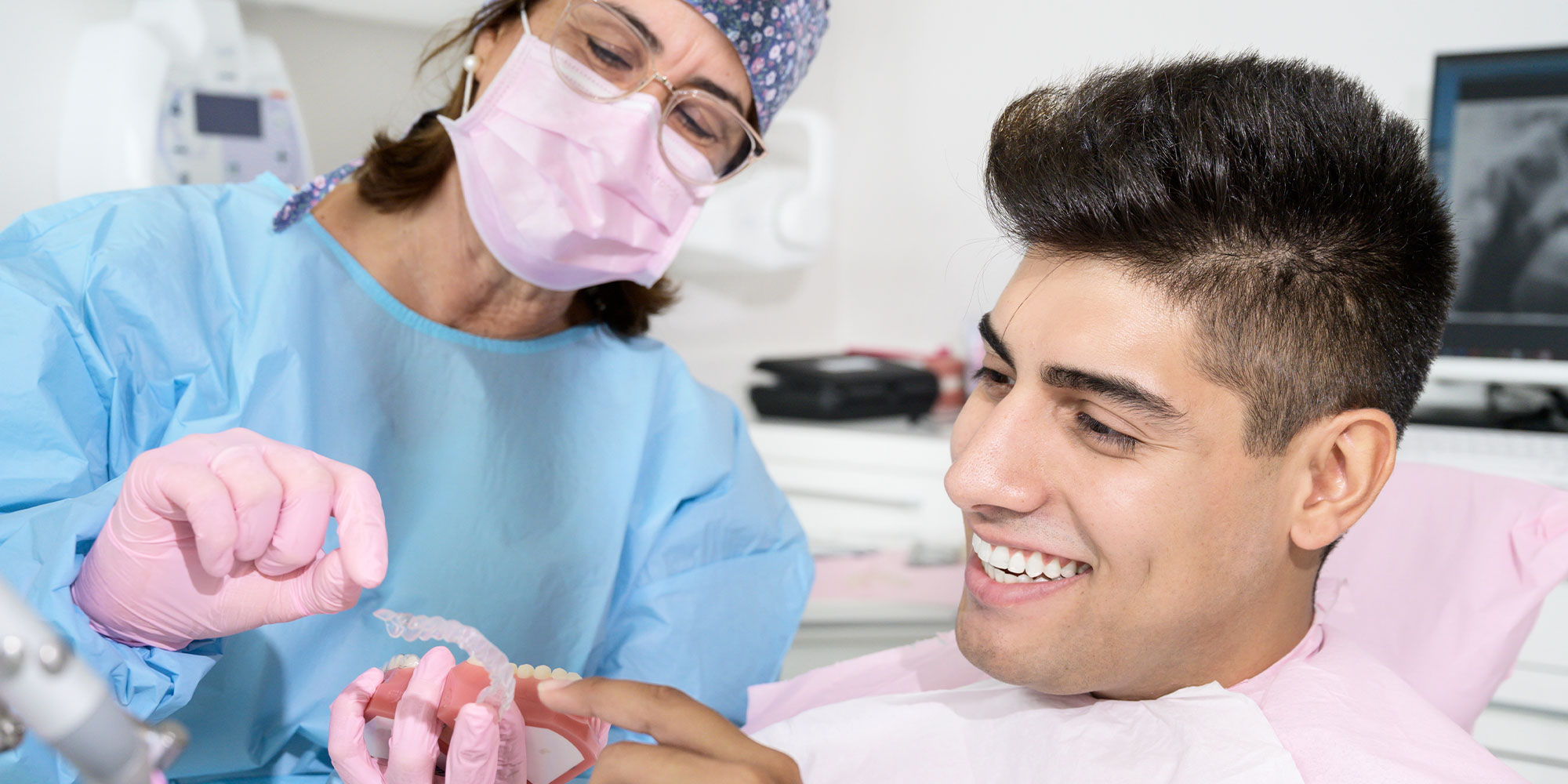 dentist showing patient Invisalign model for treatment