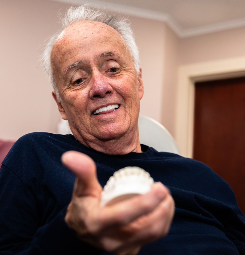 patient holding a dental crown model within the dentistry
